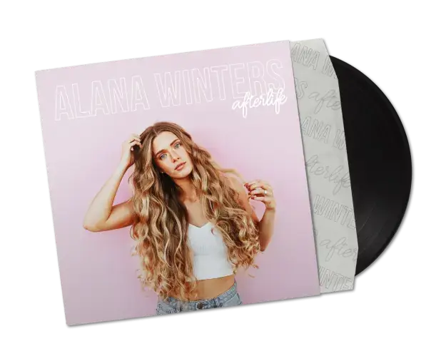 Vinyl record partially pulled out of its sleeve. The sleeve features an image of a woman with long, wavy hair wearing a white crop top and blue jeans against a pink background. The text on the sleeve reads 'ALANA WINTERS’ and ‘afterlife' in large, white letters.